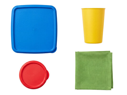 Group of essential colorful plastic household items, including food storage lids, a cup, and a green napkin.