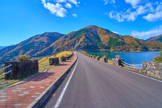 紅葉の神奈川県山北町の三保ダムの天端道路(遊歩道)から洪水吐き(水門)、六郎小屋山方面を見る