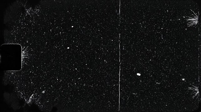 Close up of scratched and damaged vintage black film strip with dust particles and cracks on surface