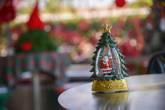 Close-up view of Christmas gifts under a decorated tree with red wrapping in a cozy home interior.