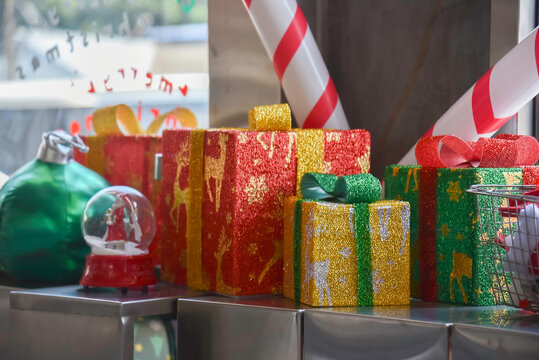 Close-up view of Christmas gifts under a decorated tree with red wrapping in a cozy home interior.