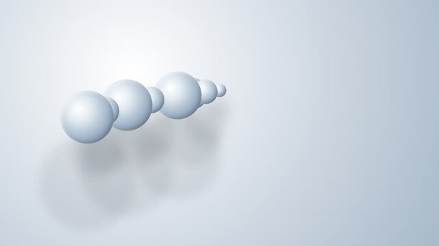 A sequence of diminishing spheres arranged in a horizontal line on light gray