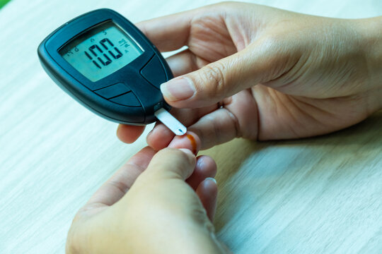 Woman's hands checking diabetes and hyperglycemia with digital blood sugar meter. Healthcare and medical concept	