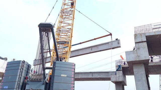 erecting a concrete precast girder (PCI Girder) using large cranes