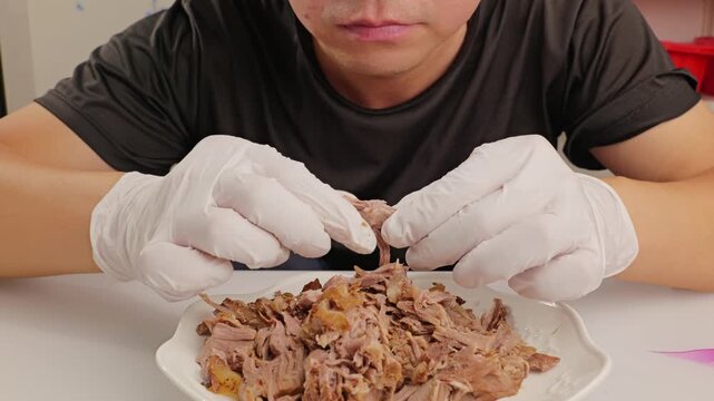 Man eating hand‑torn marinated beef.