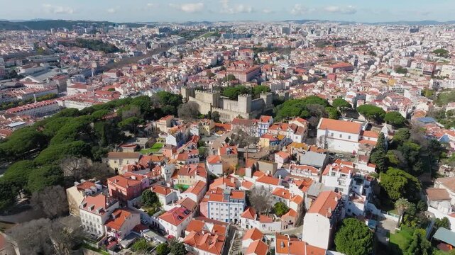 Drone panorama of Castelo de Sao Jorge, Lisbon at midday. Historic hilltop fortress, bright sunny day, clear blue sky. Portugal