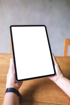 Vertical mockup image of a woman holding digital tablet with blank white desktop screen