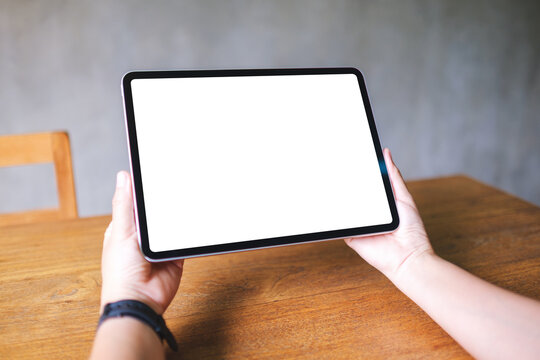 Mockup image of a woman holding digital tablet with blank white desktop screen