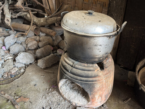 Traditional clay stove with an old aluminum cooking pot in a rustic rural kitchen