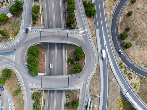 Aerial view of the A5 highway interchange featuring a roundabout with surrounding greenery and vehicles in Cascais, Lisboa, Portugal.