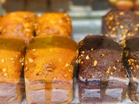 Fresh Assorted Orange and Chocolate Muffins with Nuts in Bakery Display