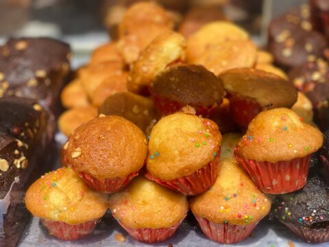 Assorted Fresh Baked Cupcakes and Brownies Displayed at a Bakery