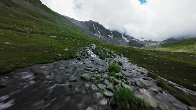 Forward aerial drone tracking shot of a flowing mountain stream
