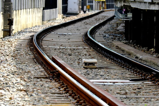 Railroad tracks curving at a station platform during daytime