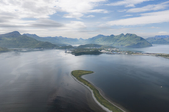 Aerial view of the coastal landscape and bay in Unalaska, with mountains in the background and a small spit of land in the foreground, Unalaska, Alaska, United States.
