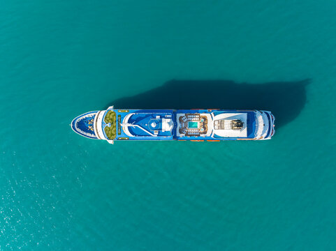 Aerial view of a large cruise ship sailing on clear turquoise waters, showing the deck layout with a swimming pool and sun loungers Koh Samui, Surat Thani, Thailand.