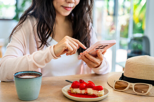 Social media content creation and travel blogging: Young female sharing cafe lifestyle moments and sweet treats online