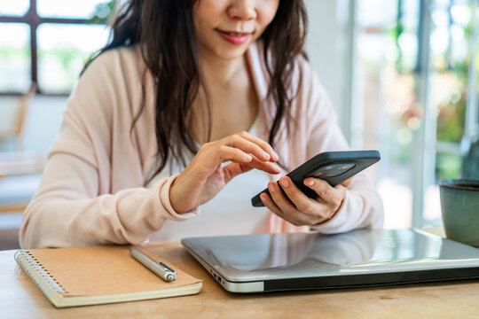 Cozy lifestyle and digital nomad: Female entrepreneur browsing social media or checking messages at a bright workspace