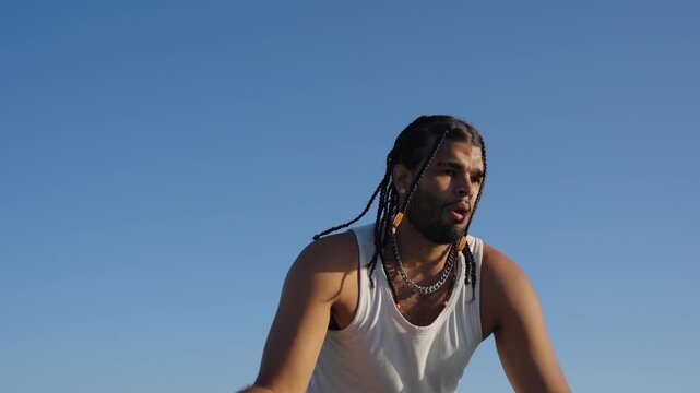 Young man with braids shooting a basketball outdoors