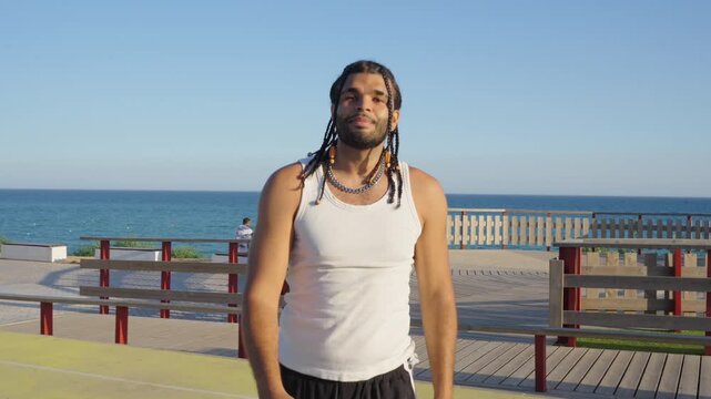 Young man scoring a basket on a seaside court