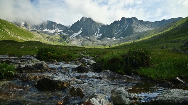 Clear mountain stream flowing through alpine valley
