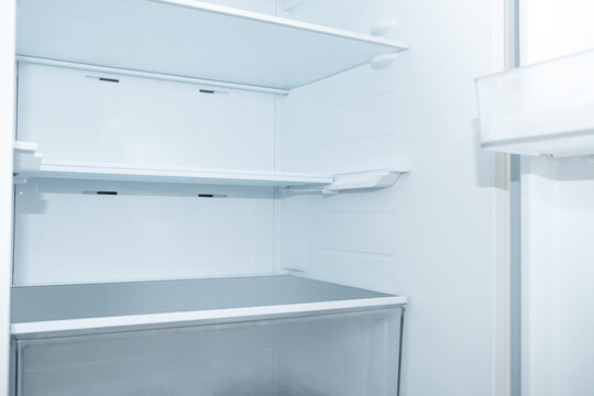 Fridge interior reveals empty shelves, highlighting storage potential