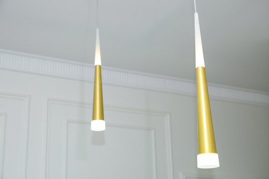 Elegant pendant lights illuminate cozy modern interior. Lighting design concept
