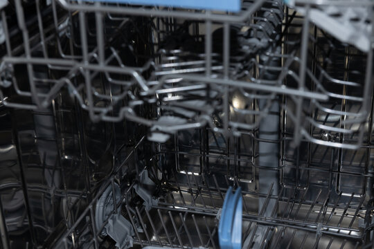 Dishwasher interior reveals organized rack components awaiting dishes