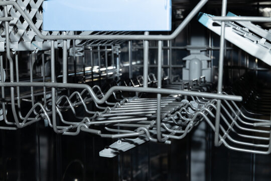 Empty dishwasher interior showcases organized rack and stainless steel design