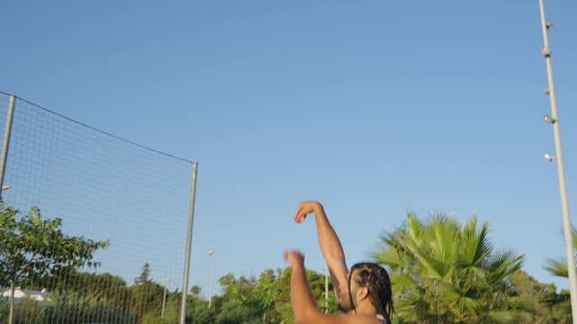 Young man dribbling and shooting basketball outdoors