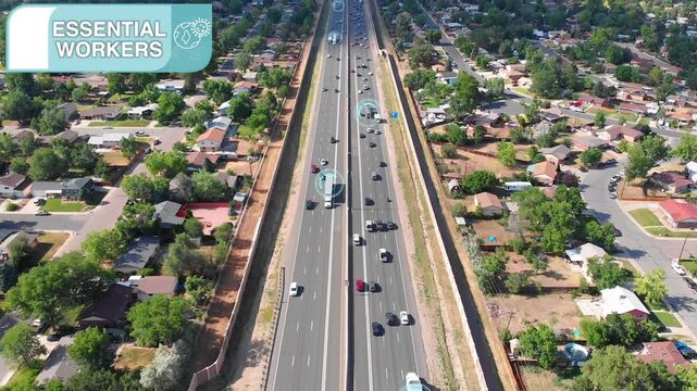 Aerial drone footage of essential workers commuting on a busy highway during daylight hours.