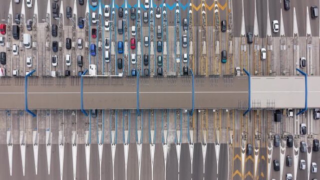 Overhead view of continuous vehicle movement through a major motorway toll barrier, illustrating transport infrastructure, road capacity and regional mobility in northern Italy.