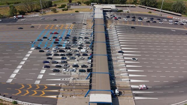 Large numbers of vehicles pass through the Milano Sud toll station on the A1 motorway, creating a clear aerial view of busy highway traffic and toll collection infrastructure near Milan.