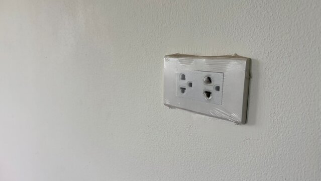 Double plug socket on the white wall , isolate.