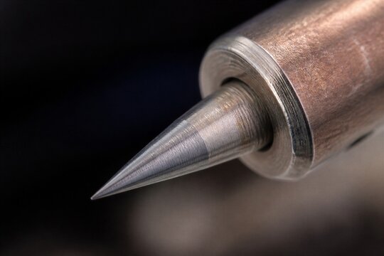 Mechanical drill bit tip close up showing macro metallic surface