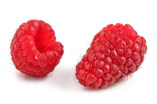 Two fresh ripe red raspberries isolated on white background close up Macro view of studio fruit.