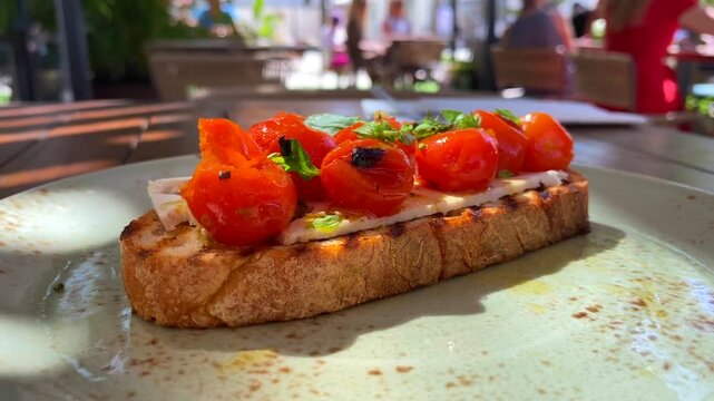 Delicious bruschetta with roasted cherry tomatoes and cheese on grilled bread close up.