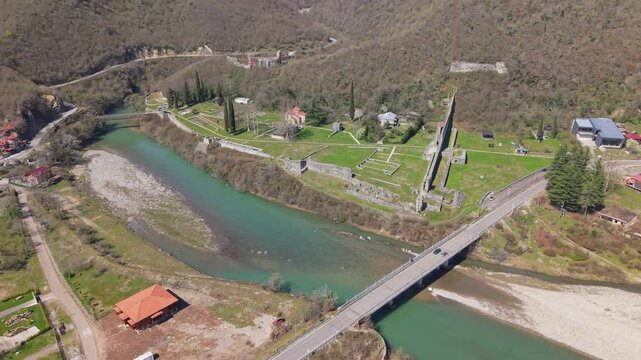 Aerial footage of Nokalakevi Fortress revealing the river winding through the lush Georgian landscape, with the ancient hilltop ruins surrounded by dramatic natural scenery.