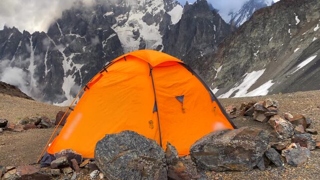 Expedition tent pitched in wide view below Mount Ushba in Svaneti, Georgia, outdoor scene for alpine camping, high-altitude trekking, expedition shelter, adventure tourism, and gear marketing.