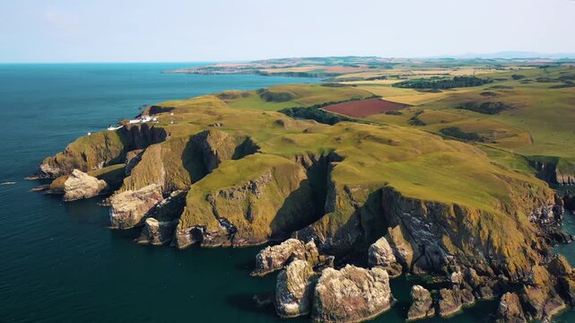 Aerial view of majestic scottish coastline featuring steep cliffs and rocky inlets.