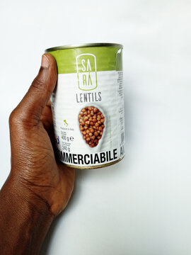 African holding can of Sara Lentils on white background. Canned Lentils packed in brine with sealed metal lid. By Sara, Italy. Kumasi, Ghana - April 16, 2026