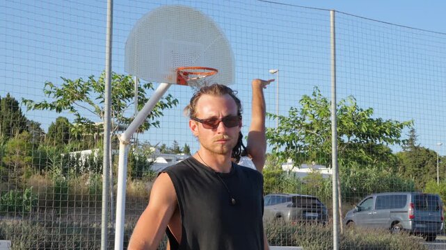 Caucasian man holding basketball looking at camera