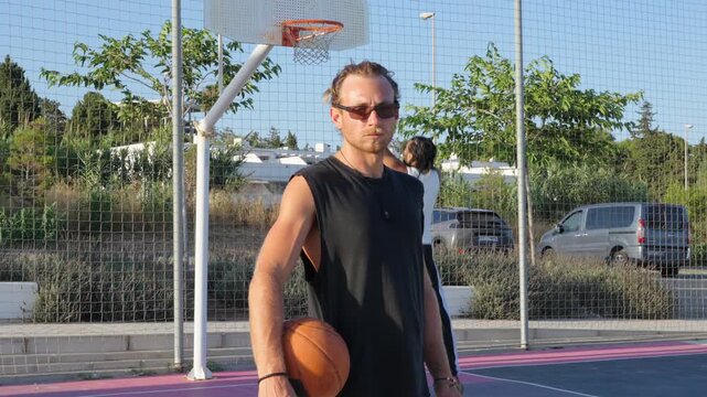 Determined athlete playing basketball outdoors on a sunny day