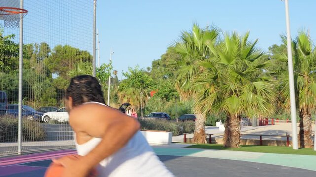 Young man with braids playing basketball and scoring