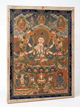 A detailed Tibetan Thangka painting featuring a multi-armed deity seated on a lotus throne in art.