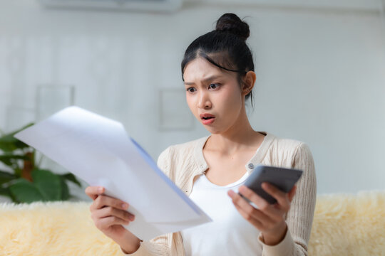 Worried woman checking bills and calculator at home, shocked by rising expenses and debt, finance, bills, budget, money, payment, stress. Financial stress concept.