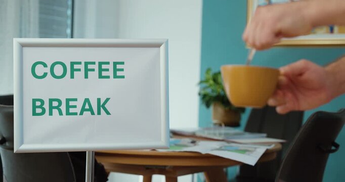 Person preparing a cup of coffee during a work break, representing relaxation, workplace routine, refreshment, rest, and productivity.