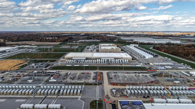 Aerial view of a large data center complex with industrial buildings, cooling units, parking lots, and surrounding landscape in New Albany, Ohio, United States.