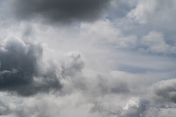 Obraz premium Dull layered overcast atmosphere. Dark threatening sky with gentle shading effects. Somber gray clouds displaying stacked stratification and subtle light transitions