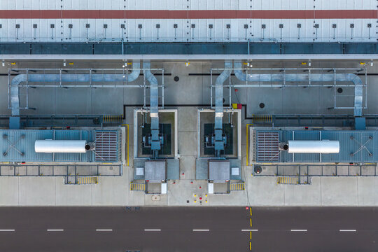 Aerial view of backup diesel generators and concrete fire barriers at a large data center facility in Poland.